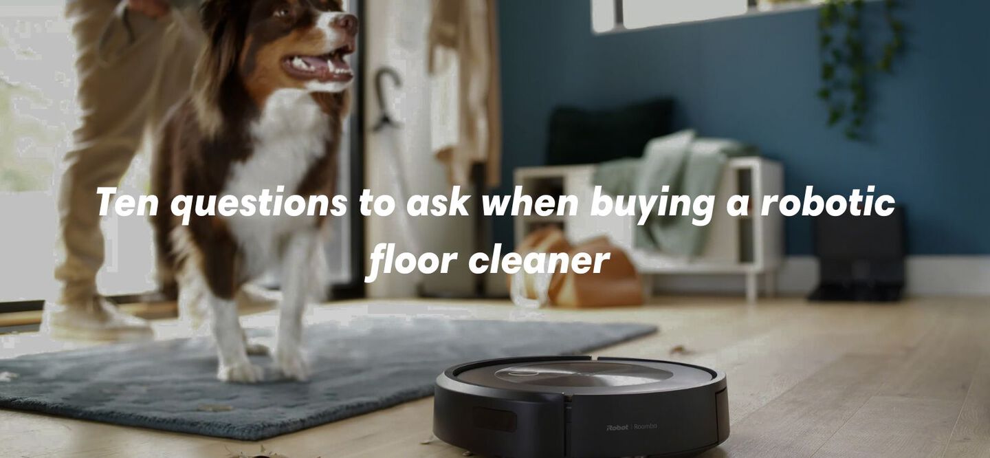 ten questions to ask when buying a robotic floor cleaner with robot vacuum roomba in foreground and dog in background